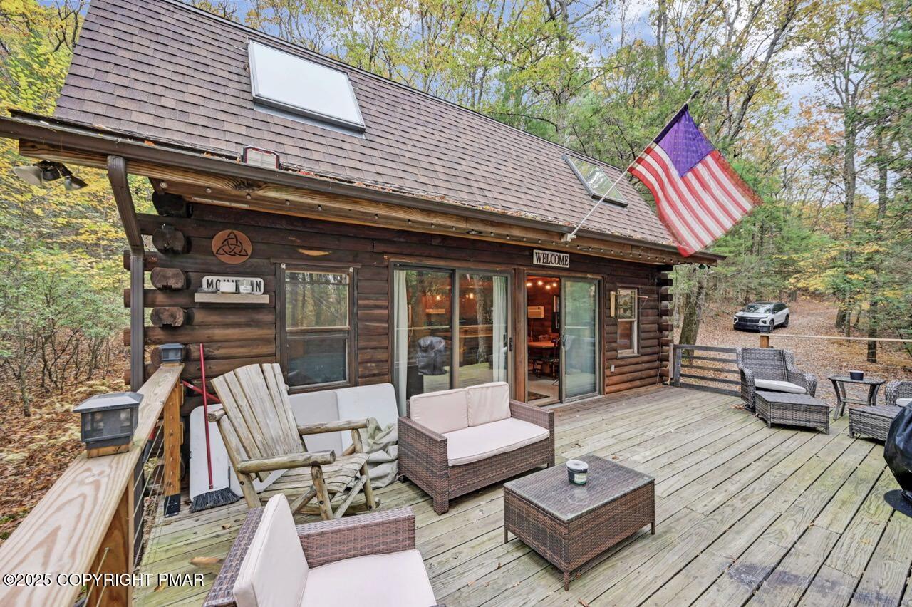 185 Whispering Pine Road Kunkletown, PA 18058 - Photo 50 of 65 a view of a patio with couches and a dining table and chairs with wooden floor