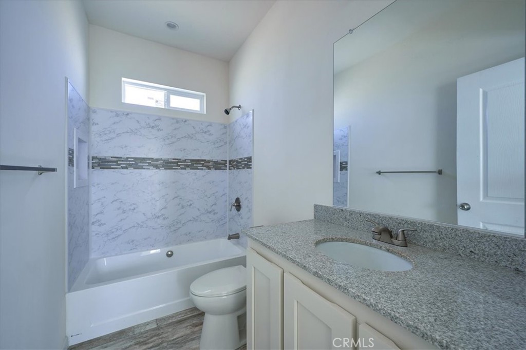 12594 Atsina Road Phelan, CA 92371 - Photo 28 of 37 a bathroom with a granite countertop sink a toilet and bathtub