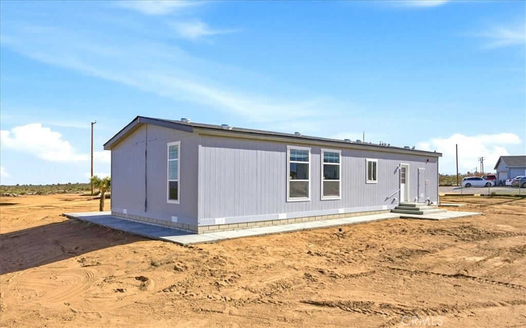 12594 Atsina Road Phelan, CA 92371 - Photo 35 of 37 a view of a house with wooden floor and yard next to a road