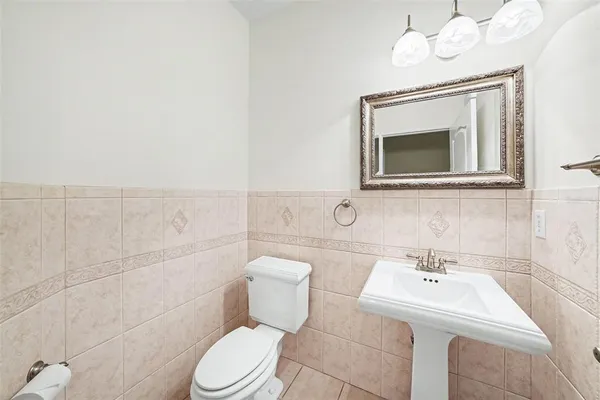 a bathroom with a toilet a sink and mirror