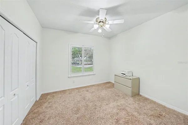 a view of an empty room with a chandelier fan