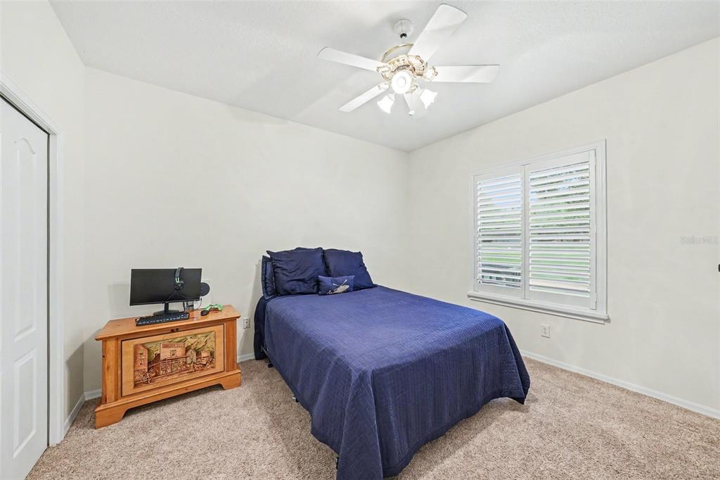 19216 Ridgelake Drive Lutz, FL 33549 - Photo 21 of 31 a bedroom with a bed and a chandelier