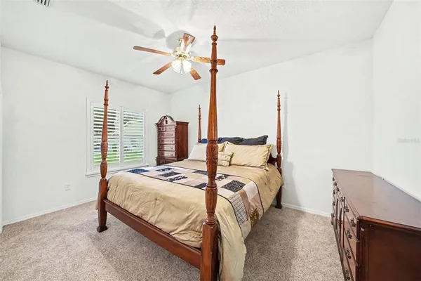 a bedroom with a bed a chandelier and the view of kitchen