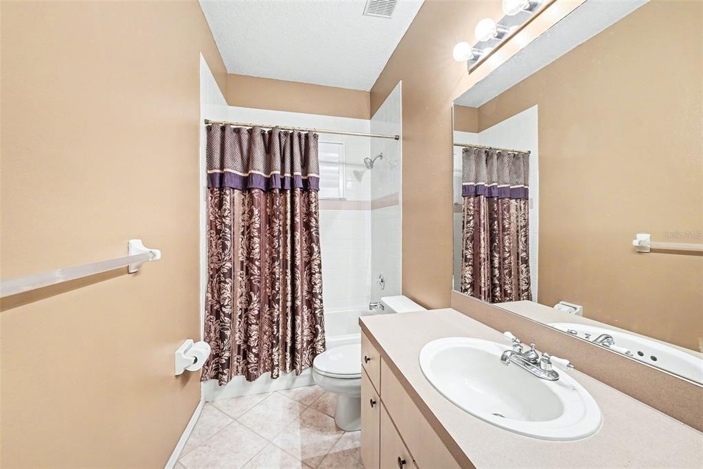 19216 Ridgelake Drive Lutz, FL 33549 - Photo 25 of 31 a bathroom with a sink a toilet and shower