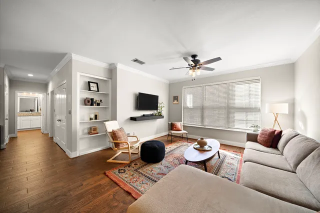 a living room with furniture a flat screen tv and a large window