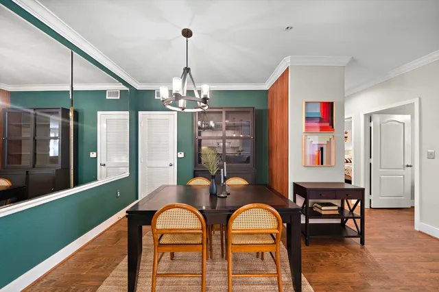 a dining room with furniture a chandelier and wooden floor