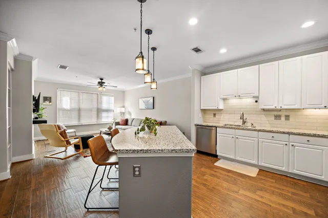 a large kitchen with kitchen island granite countertop a large counter top space and stainless steel appliances
