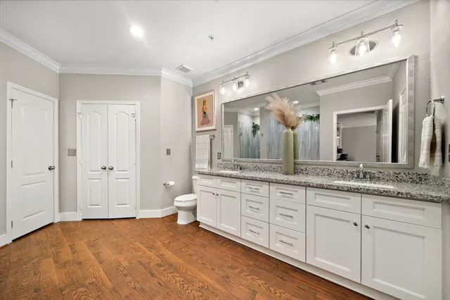 a spacious bathroom with a granite countertop sink a toilet and a mirror