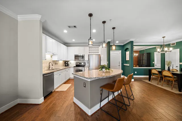 a living room with stainless steel appliances kitchen island hardwood floor and a view of living room
