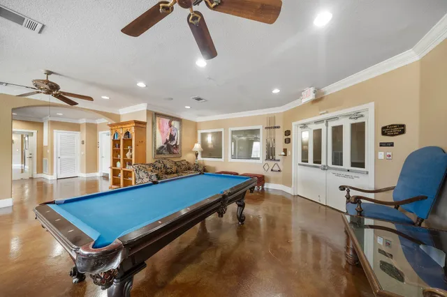 a room with furniture pool table wooden floor and windows
