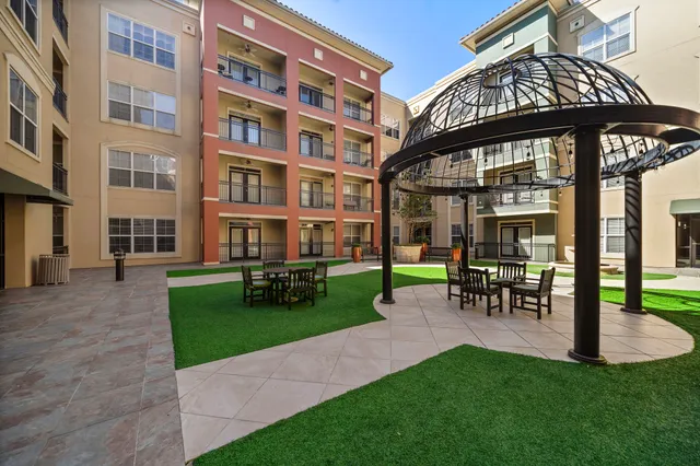 a view of a building with a garden and sitting area