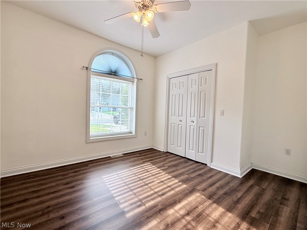 603 South Raccoon Road, Unit 1 Austintown, OH 44515 - Photo 14 of 22 Room featuring wood-finish flooring, a white bi-fold closet, and an arched window with blinds