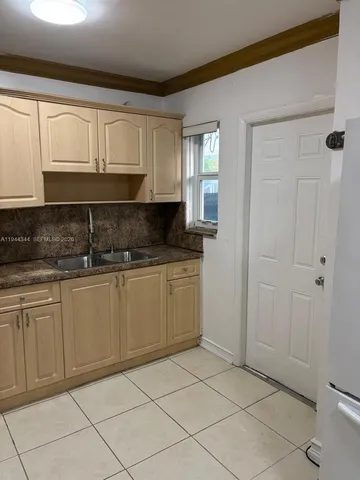 a kitchen with granite countertop white cabinets and sink