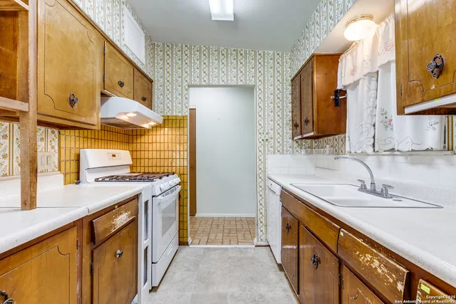a kitchen with stainless steel appliances granite countertop a sink and a stove