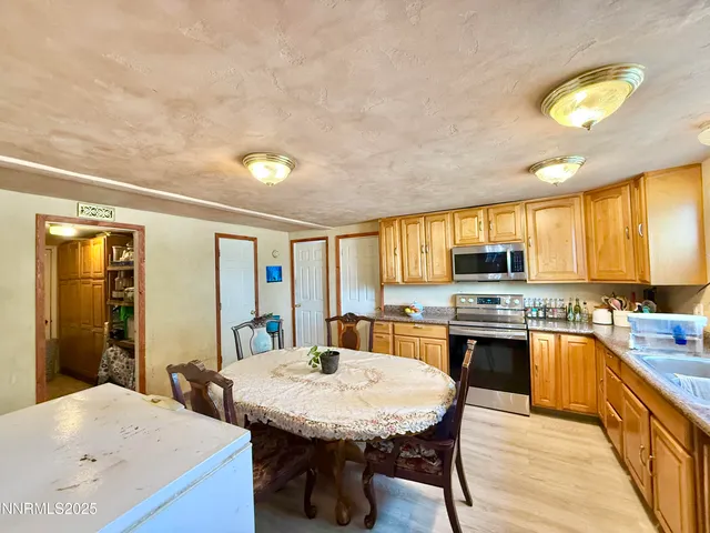 a dining area with a table chairs and a kitchen view