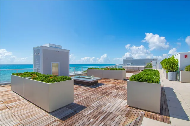 a view of a terrace with wooden floor and a garden
