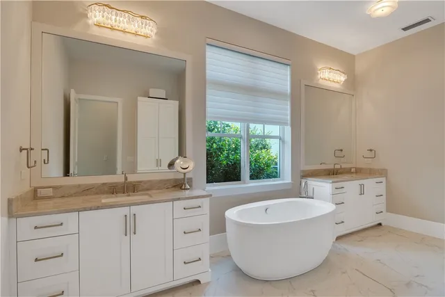 a bathroom with a granite countertop tub sink and mirror