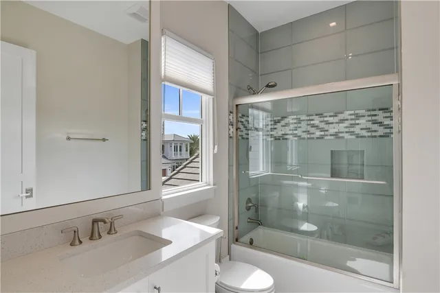 a bathroom with a shower sink vanity mirror and toilet