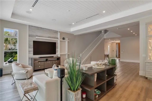 a living room with furniture a flat screen tv and a large window