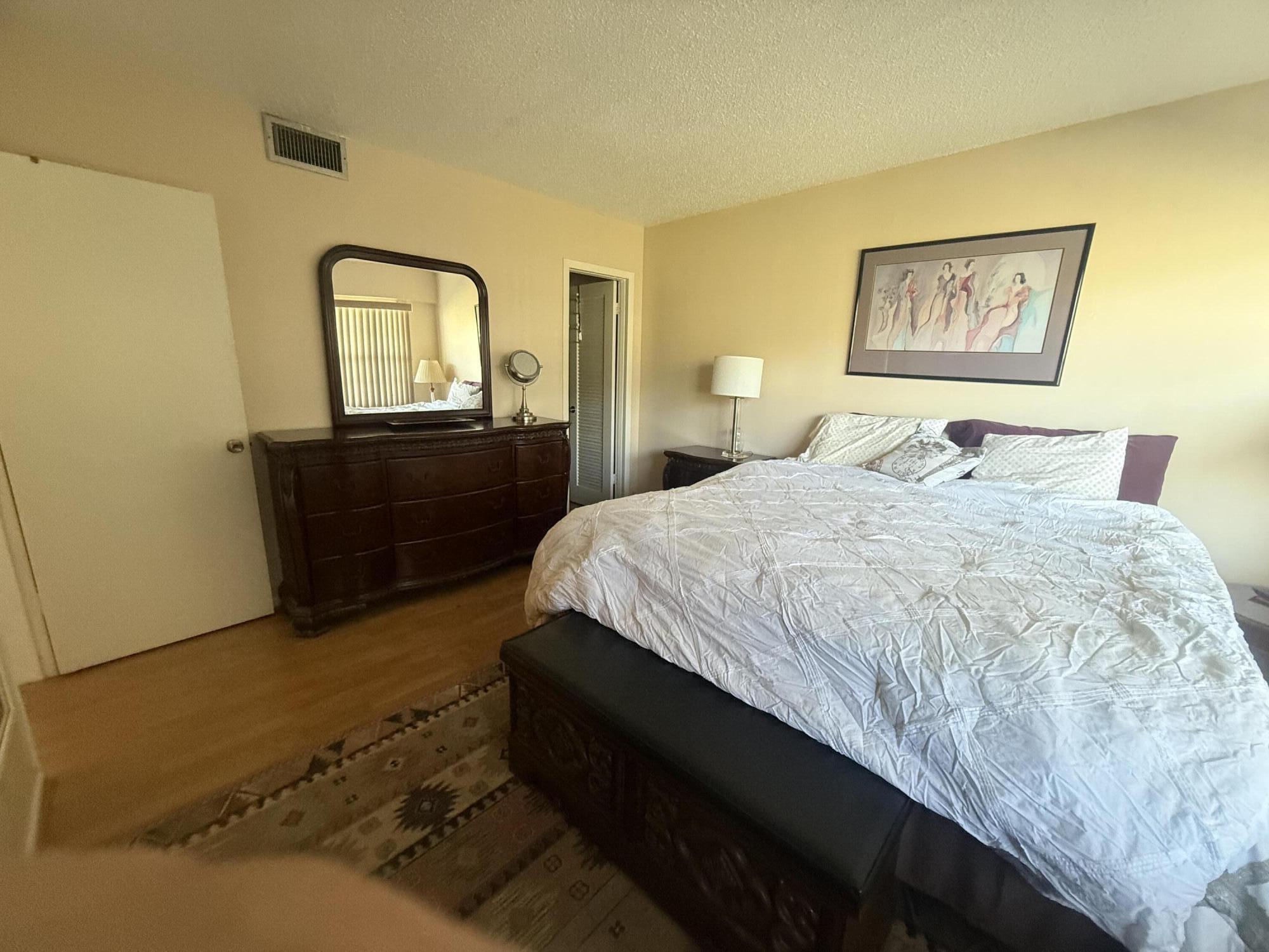 35 Suffolk A, Unit 35 Boca Raton, FL 33434 - Photo 3 of 6 a bedroom with a bed and a dresser