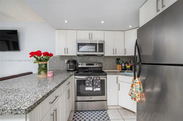a kitchen with stainless steel appliances granite countertop a refrigerator and a stove top oven