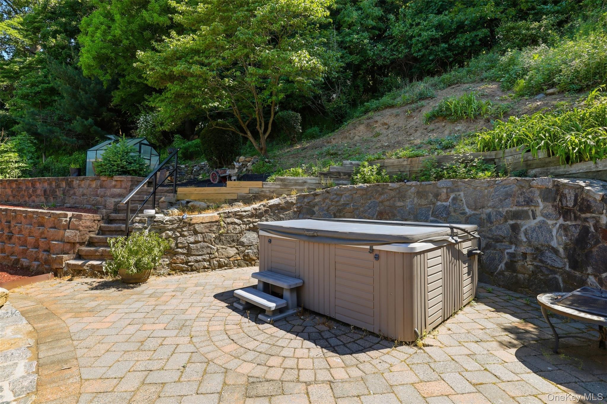 29 Montrose Road Yonkers, NY 10710 - Photo 30 of 39 Outdoor patio featuring a hot tub with cover, stone retaining walls, and paver flooring