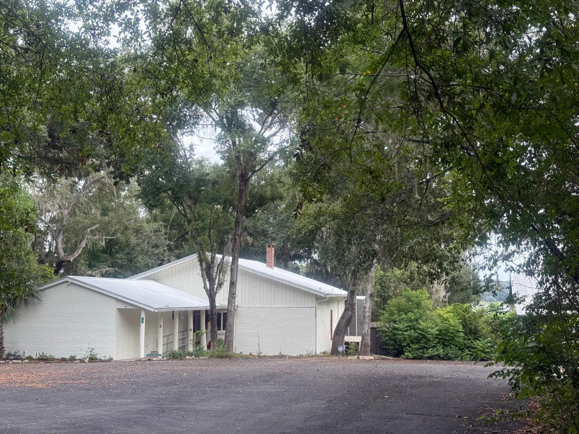397 Southeast County Road 18A Starke, FL 32091 - Photo 4 of 77 View of side of home featuring view of scattered trees and a chimney