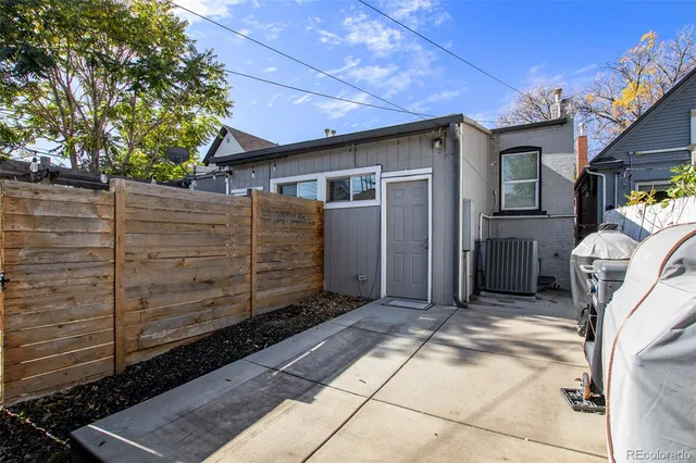 a view of a house with a small yard and wooden fence