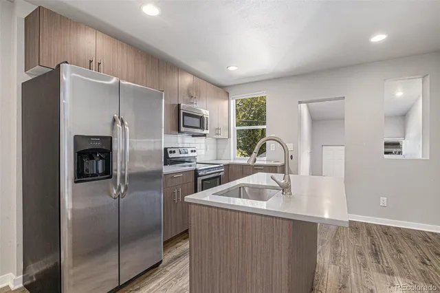 a kitchen with stainless steel appliances granite countertop a refrigerator and a sink