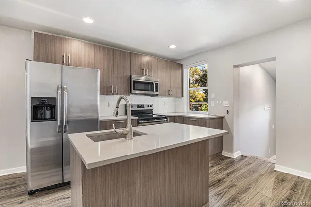 a kitchen with kitchen island a refrigerator sink and microwave