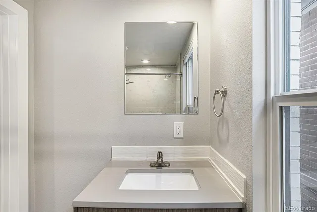 a bathroom with a sink a window and a mirror