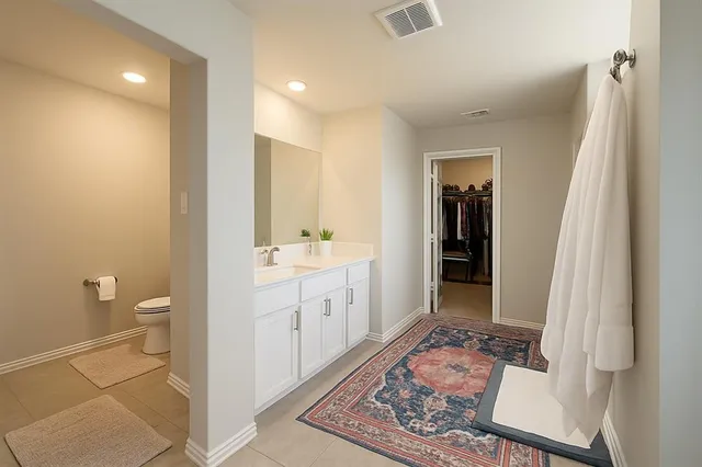 a spacious bathroom with a toilet sink and a mirror