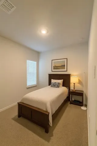 a bedroom with a bed and a lamp