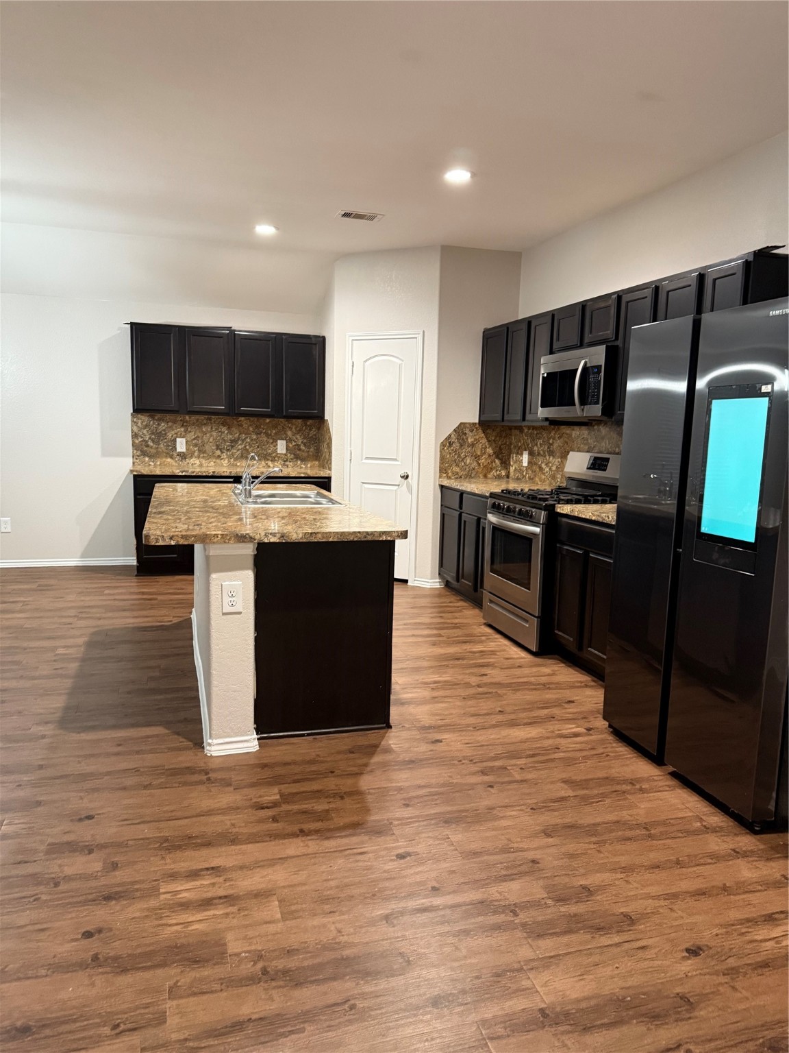 15415 Bosque Viejo Trail Channelview, TX 77530 - Photo 3 of 20 a large kitchen with stainless steel appliances granite countertop a stove top oven a sink dishwasher and a refrigerator