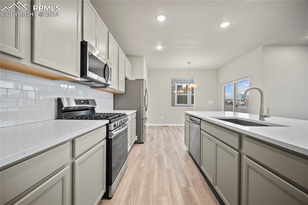 8093 Yellowleaf Place Colorado Springs, CO 80908 - Photo 12 of 23 a kitchen with stainless steel appliances granite countertop a sink stove and cabinets
