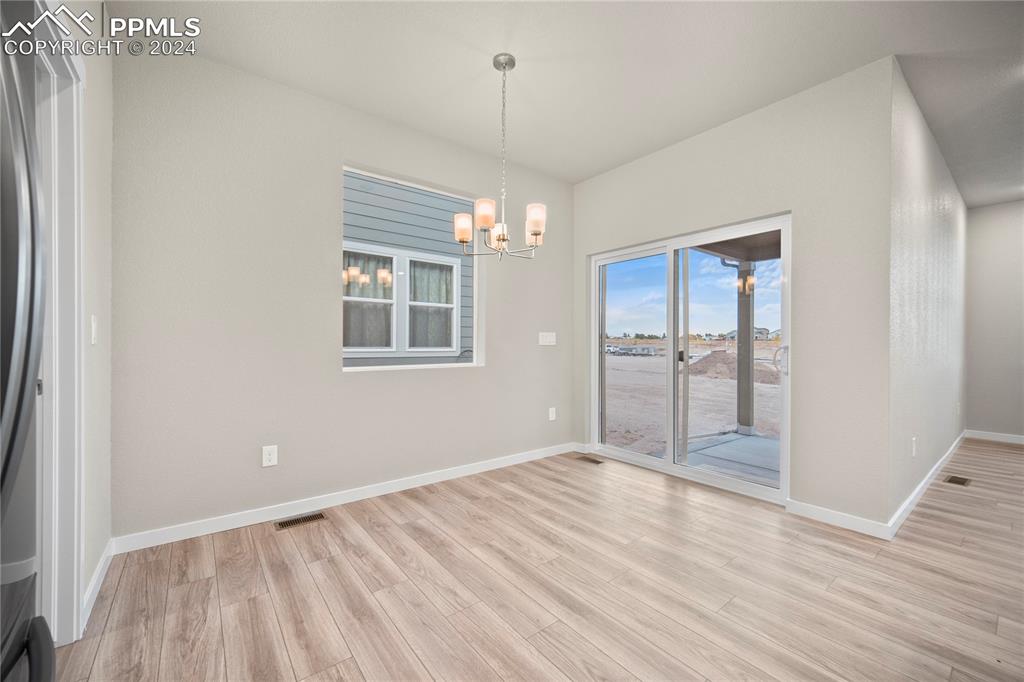 8093 Yellowleaf Place Colorado Springs, CO 80908 - Photo 13 of 23 a view of an empty room with wooden floor and a window
