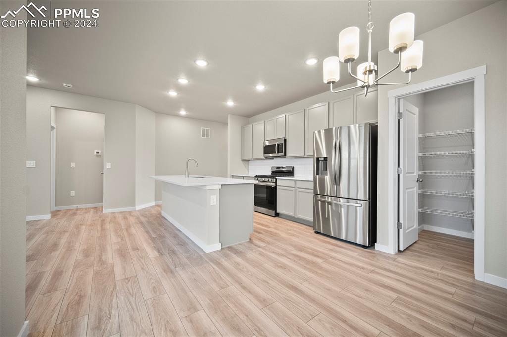 8093 Yellowleaf Place Colorado Springs, CO 80908 - Photo 14 of 23 a view of kitchen with refrigerator microwave and wooden floor