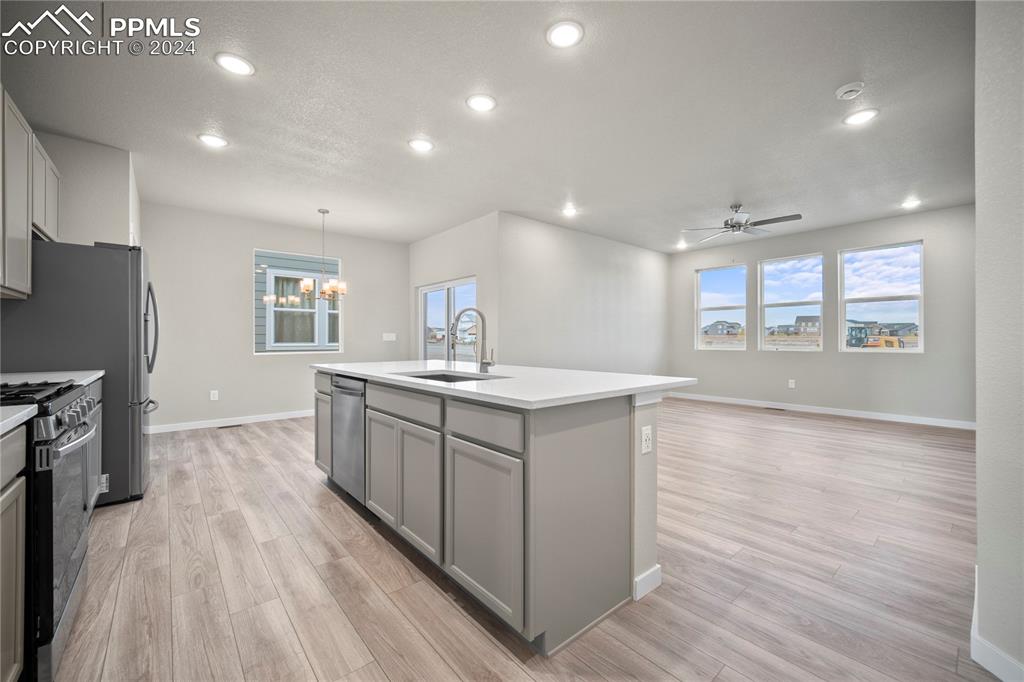 8093 Yellowleaf Place Colorado Springs, CO 80908 - Photo 23 of 23 a large kitchen with stainless steel appliances a large counter top a stove and a sink