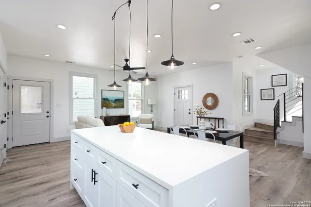 a large kitchen with stainless steel appliances a large center island attached withe living room