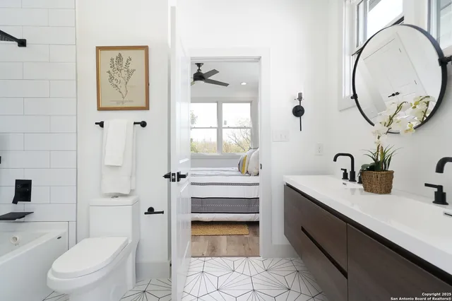 a bathroom with a sink a toilet and a mirror