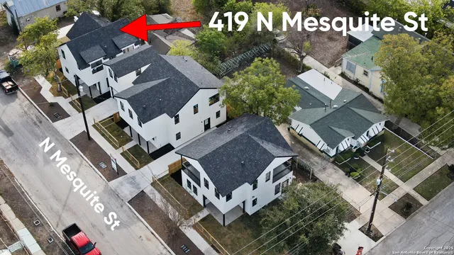 aerial view of multi story residential apartment building with yard