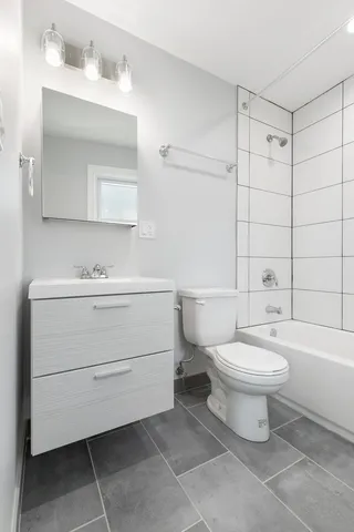 a bathroom with a white toilet sitting next to a bathroom sink and a shower