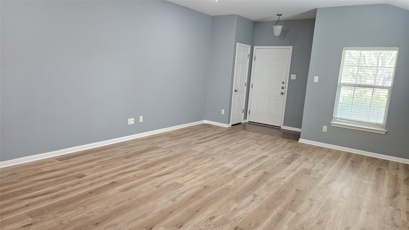 3708 Hawk View Street Round Rock, TX 78665 - Photo 3 of 12 an empty room with wooden floor and windows