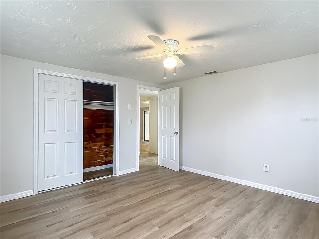6632 Sierra Terrace New Port Richey, FL 34652 - Photo 19 of 49 an empty room with wooden floor fan and windows