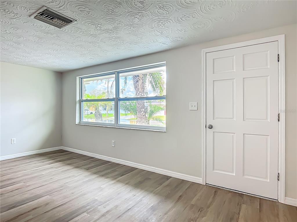 6632 Sierra Terrace New Port Richey, FL 34652 - Photo 5 of 49 an empty room with wooden floor and windows