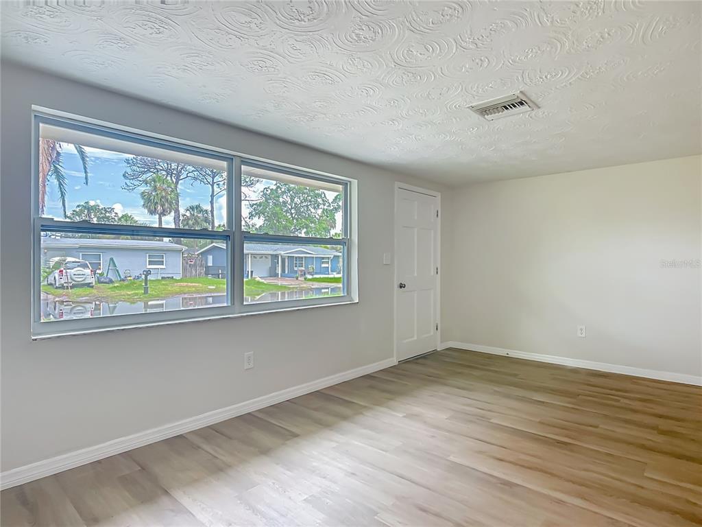 6632 Sierra Terrace New Port Richey, FL 34652 - Photo 8 of 49 an empty room with wooden floor and windows
