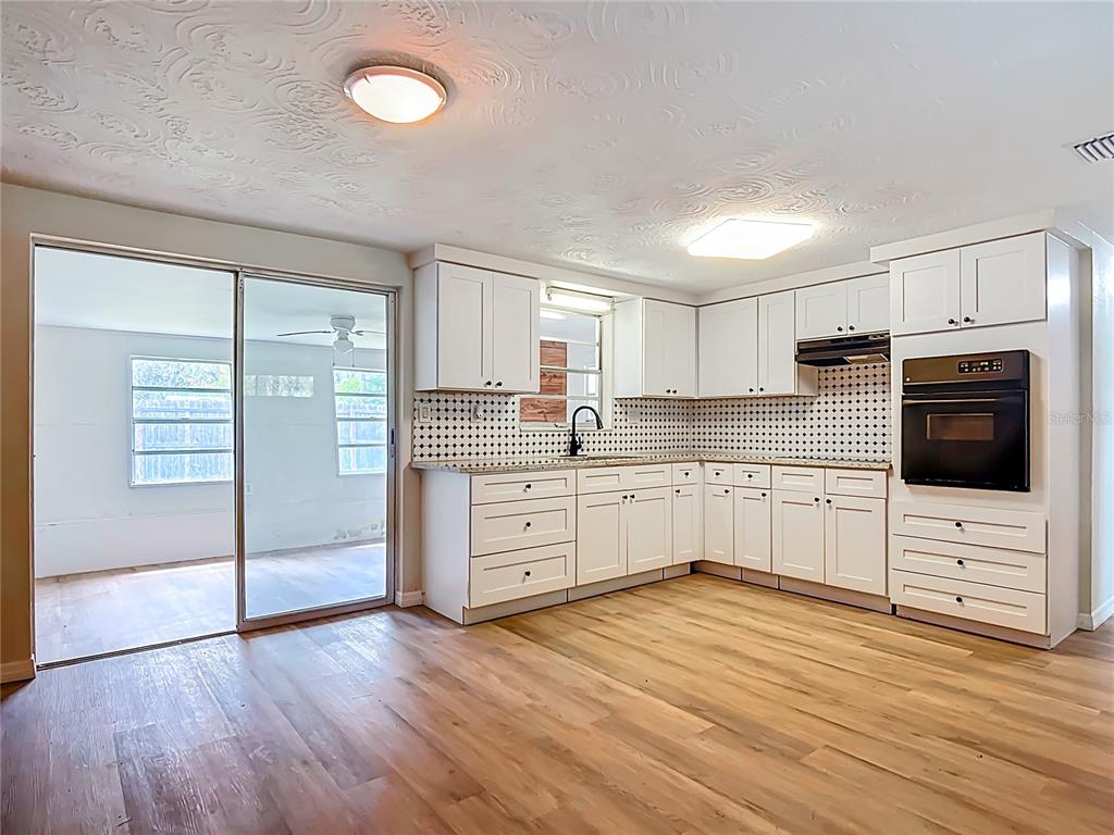 6632 Sierra Terrace New Port Richey, FL 34652 - Photo 9 of 49 a kitchen with stainless steel appliances a stove top oven and a wooden floors