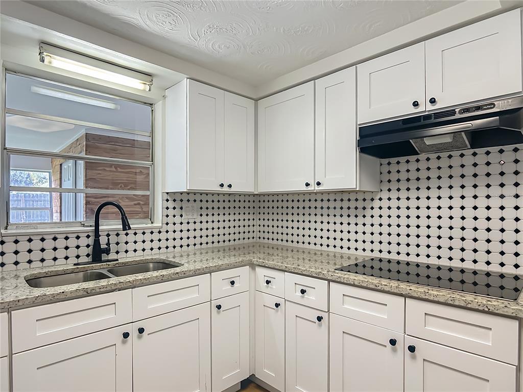 6632 Sierra Terrace New Port Richey, FL 34652 - Photo 10 of 49 a kitchen with granite countertop white cabinets and sink