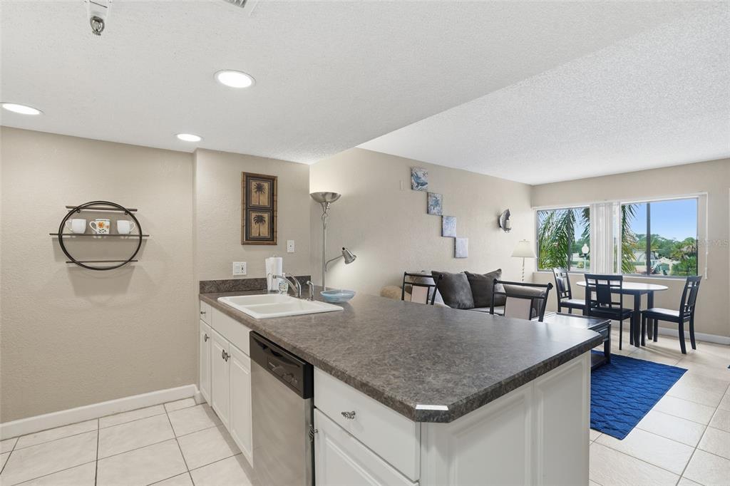 3170 Matecumbe Key Road, Unit 127 Punta Gorda, FL 33955 - Photo 5 of 22 a kitchen with granite countertop a table chairs and white cabinets