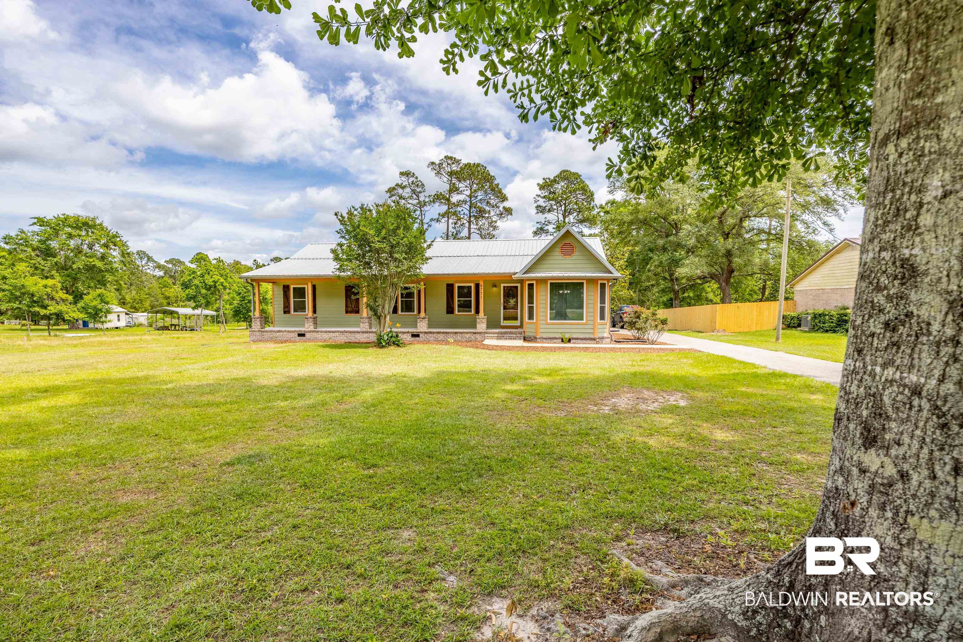 9771 Clarke Ridge Road Foley, AL 36535 - Photo 62 of 72 View of front of house with covered porch, metal roof, fence, and a front yard.